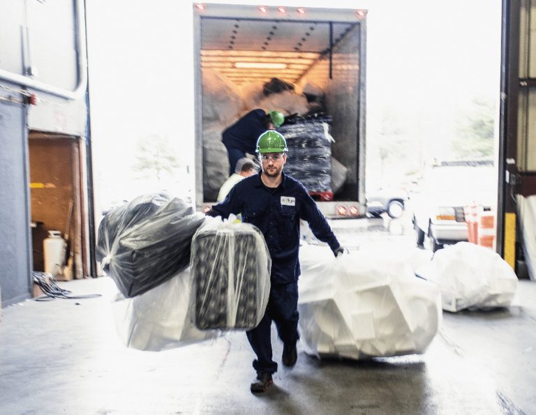 An Agilyx employee carrying waste styrofoam in the plastic recycling facility in Tigard, Oregon.