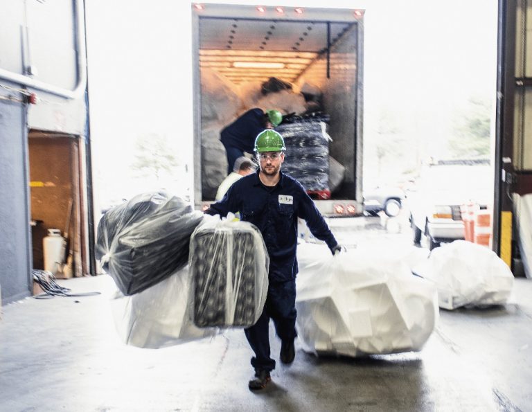 An Agilyx employee carrying polystyrene waste.