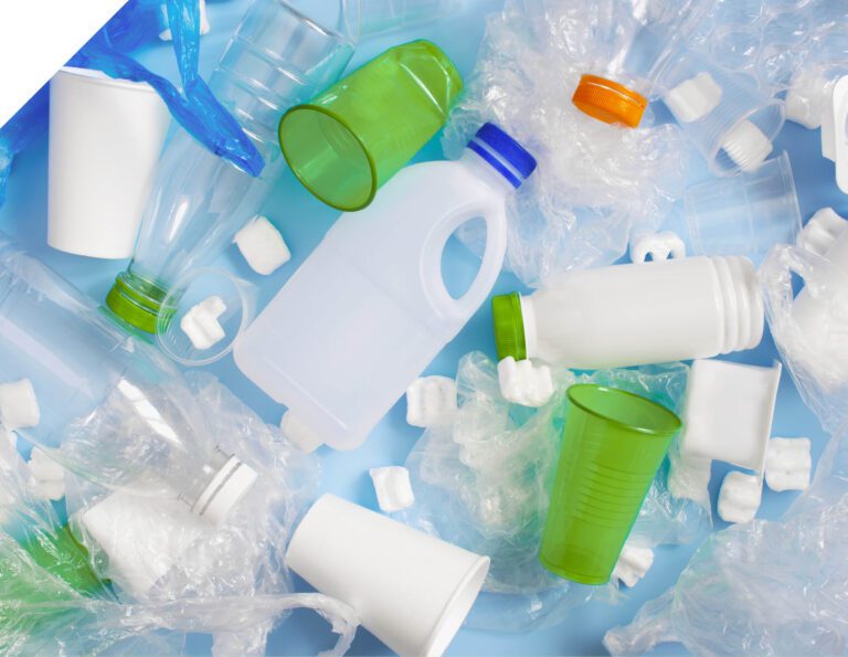 Various plastic garbage on the light blue background, problem of waste sorting and utilization